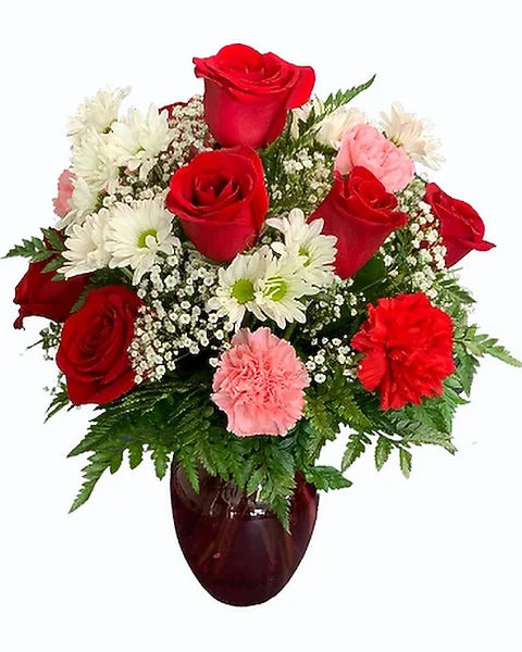 Bouquet of red roses, white flowers, and pink carnations in a vase 