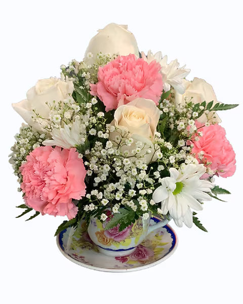 Floral arrangement with pink and white flowers in a teacup 