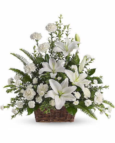 Floral arrangement with white lilies and greenery in a woven 